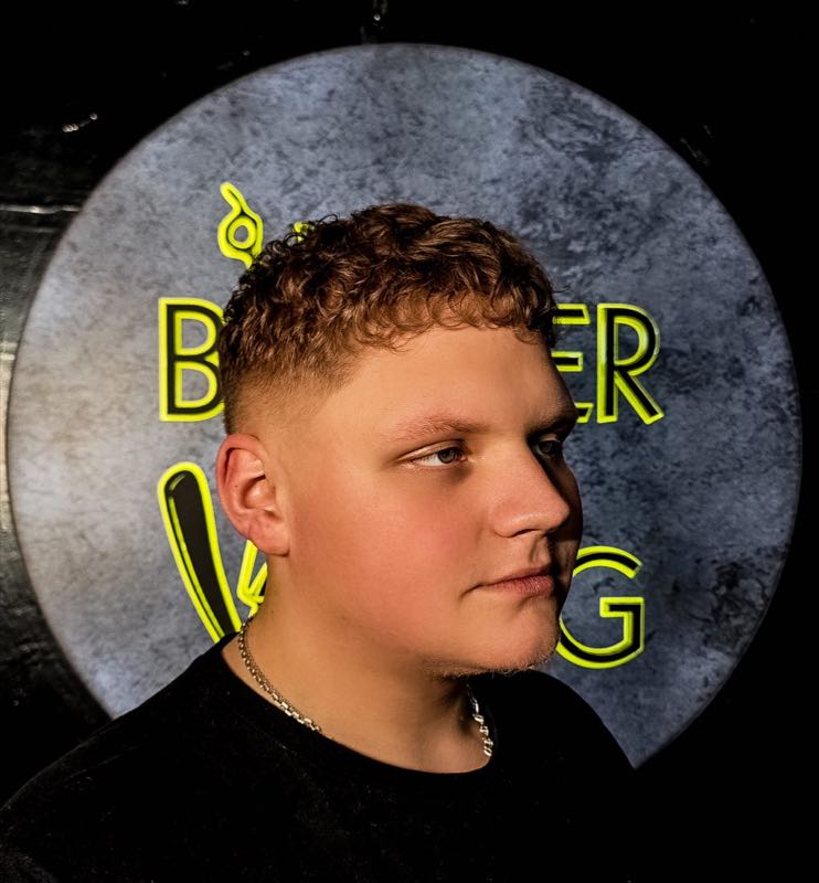 Текстурная стрижка на фоне неоновой вывески Barber Viking