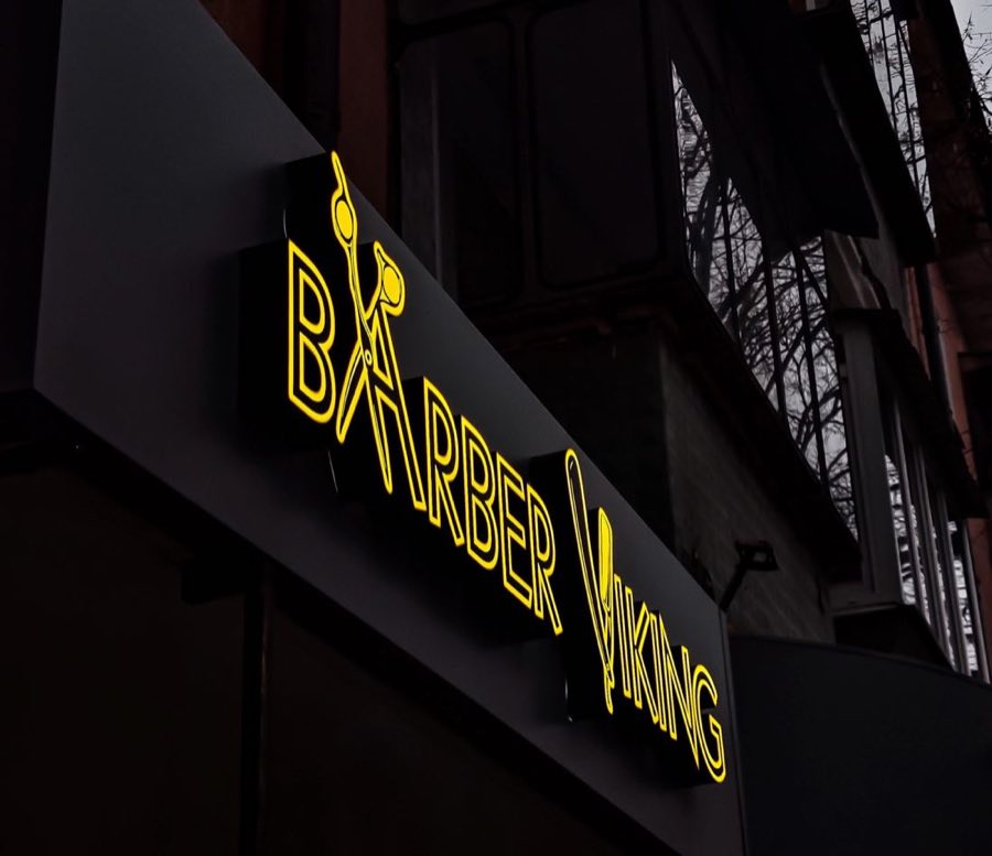 Жёлтая неоновая вывеска Barber Viking над входом